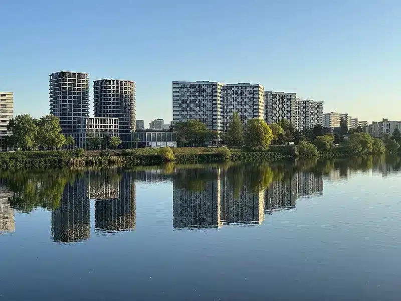 Vue des immeubles de l’Île de Nantes reflétés dans la Loire au lever du soleil